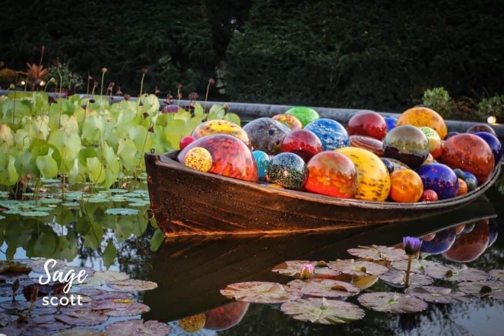 A boat filled with blown glass orbs floats in a pond at the Biltmore Estates