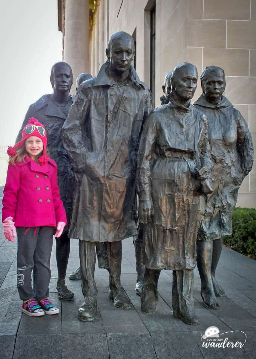 A child blends in with bronze workers in George Segal's Rush Hour in Kansas City