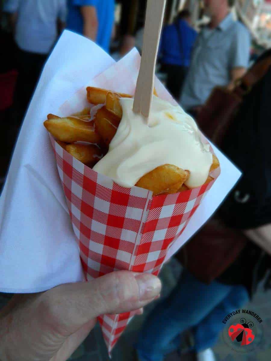 Dutch French fries (frites) topped with mayonnaise in a paper cone