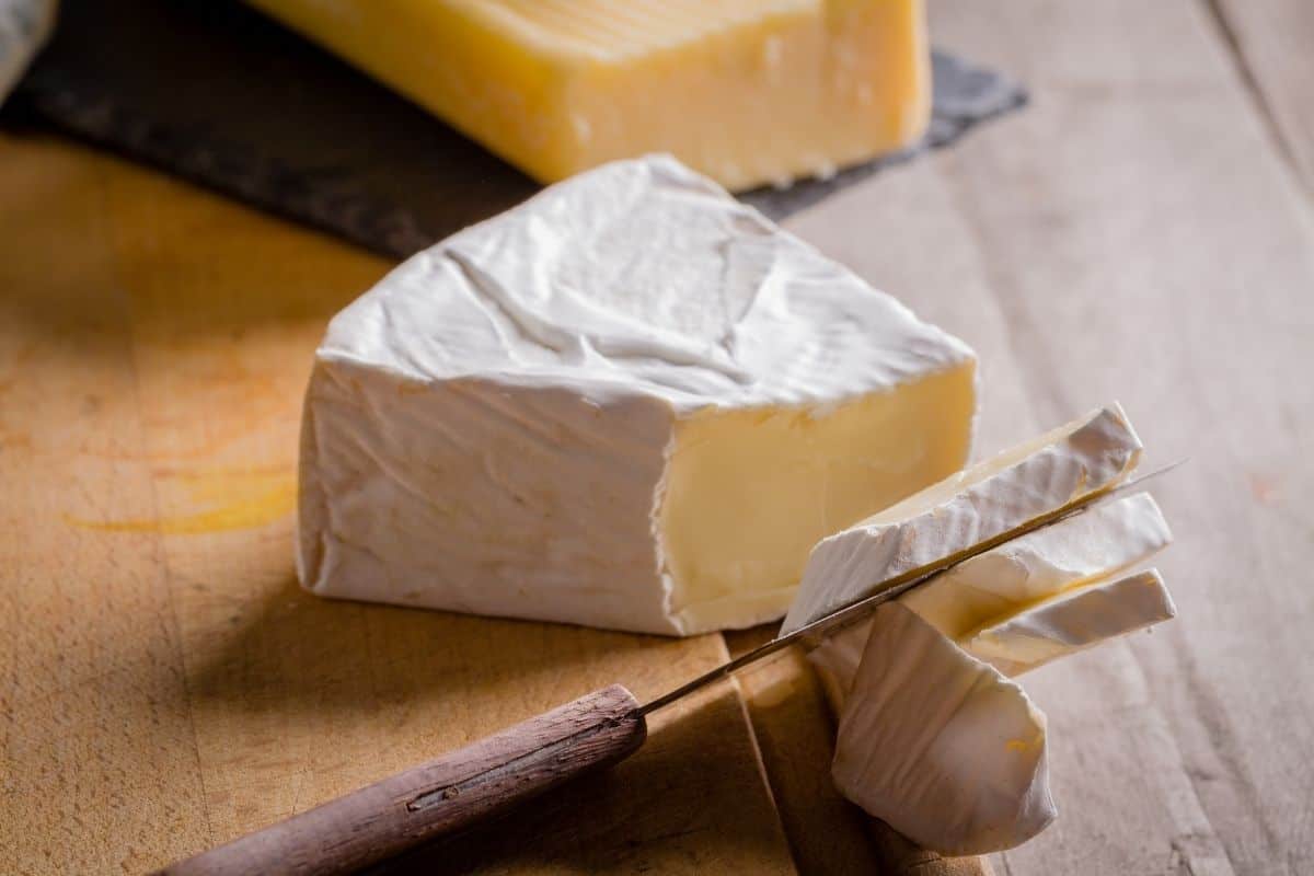 A triangle of brie on a cutting board