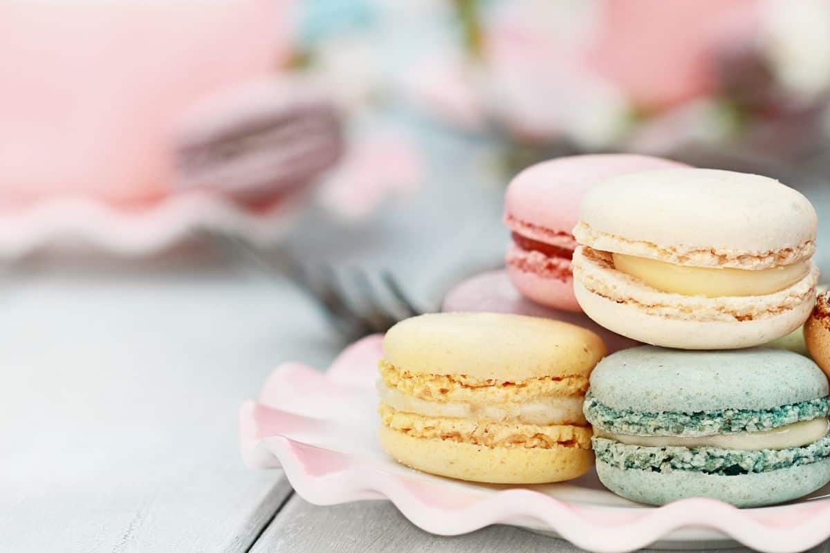 A stack of pastel-colored macarons on a pretty dessert plate