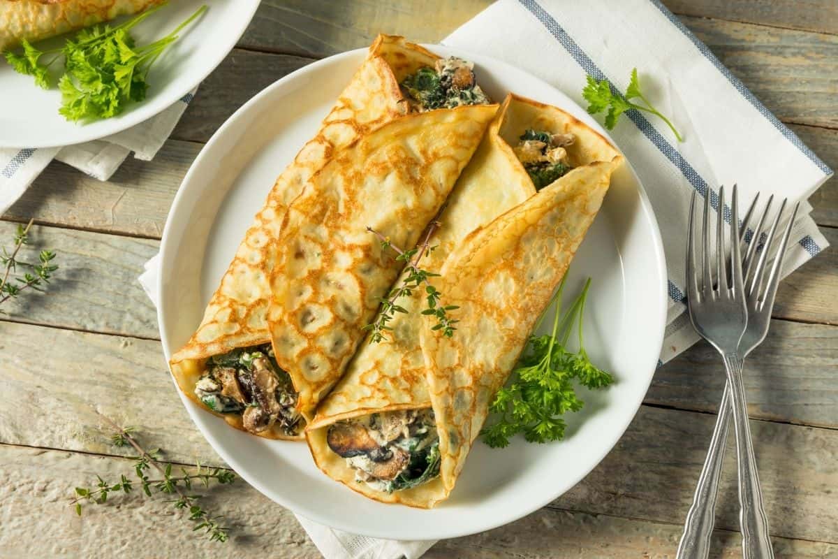 A plate of savory French crepes on a wooden table