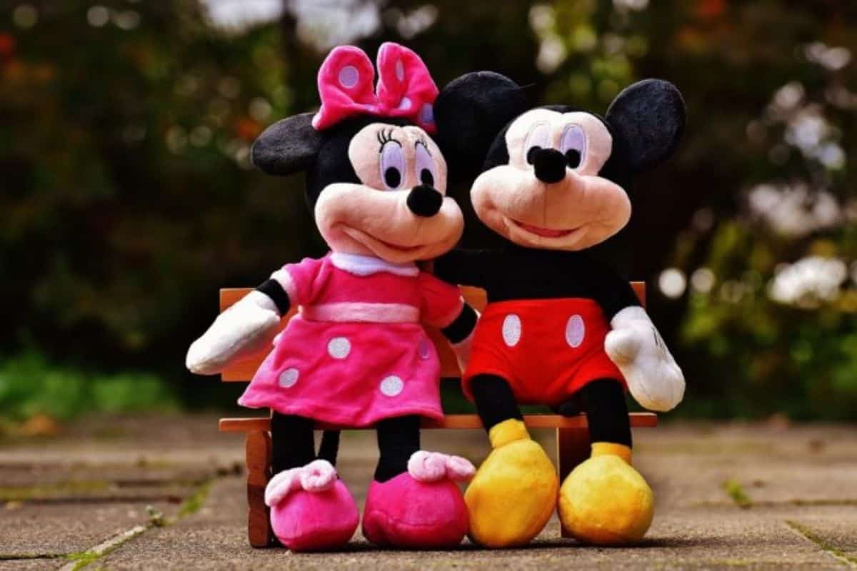 Mickey Mouse and Minnie Mouse stuffed animals sitting on a bench
