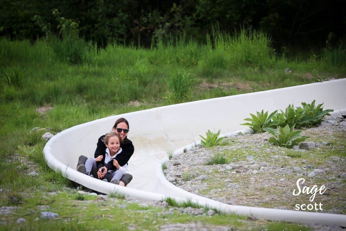 A mother and child ride down the alpine slide
