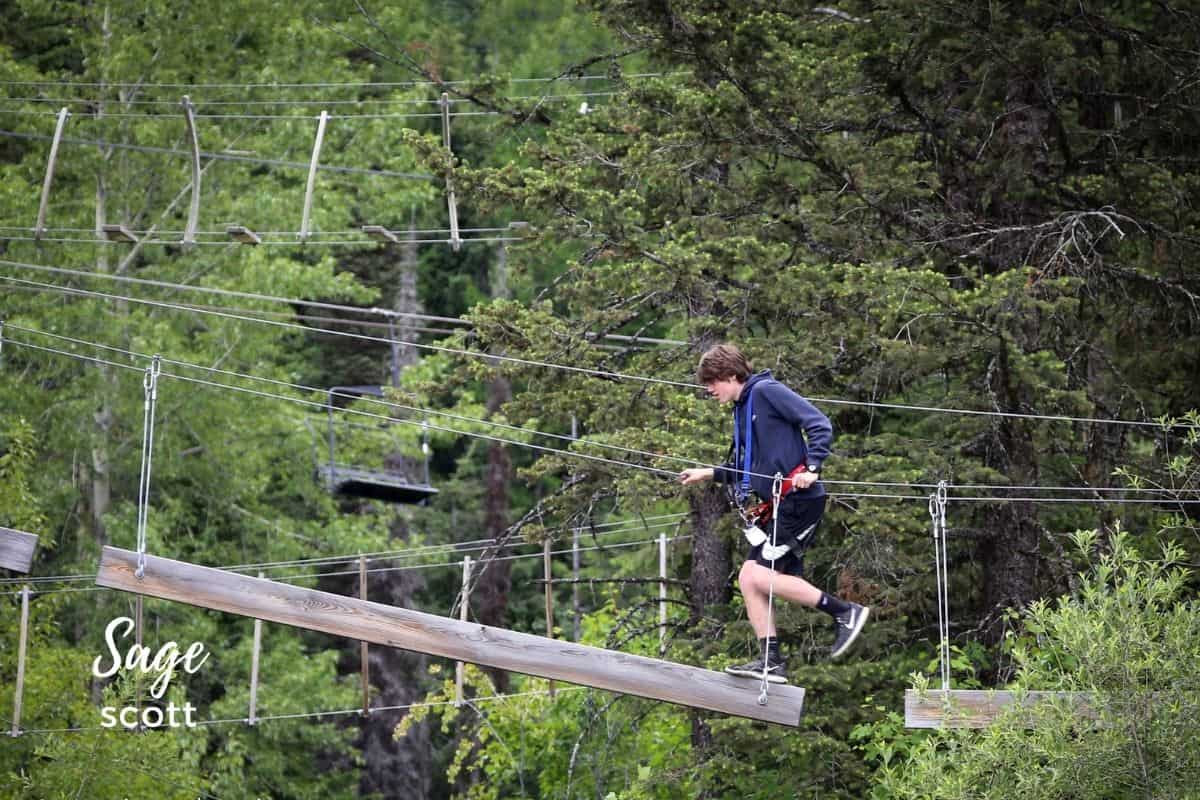 A boy climbs on the obstacle course at Whitefish Mountain