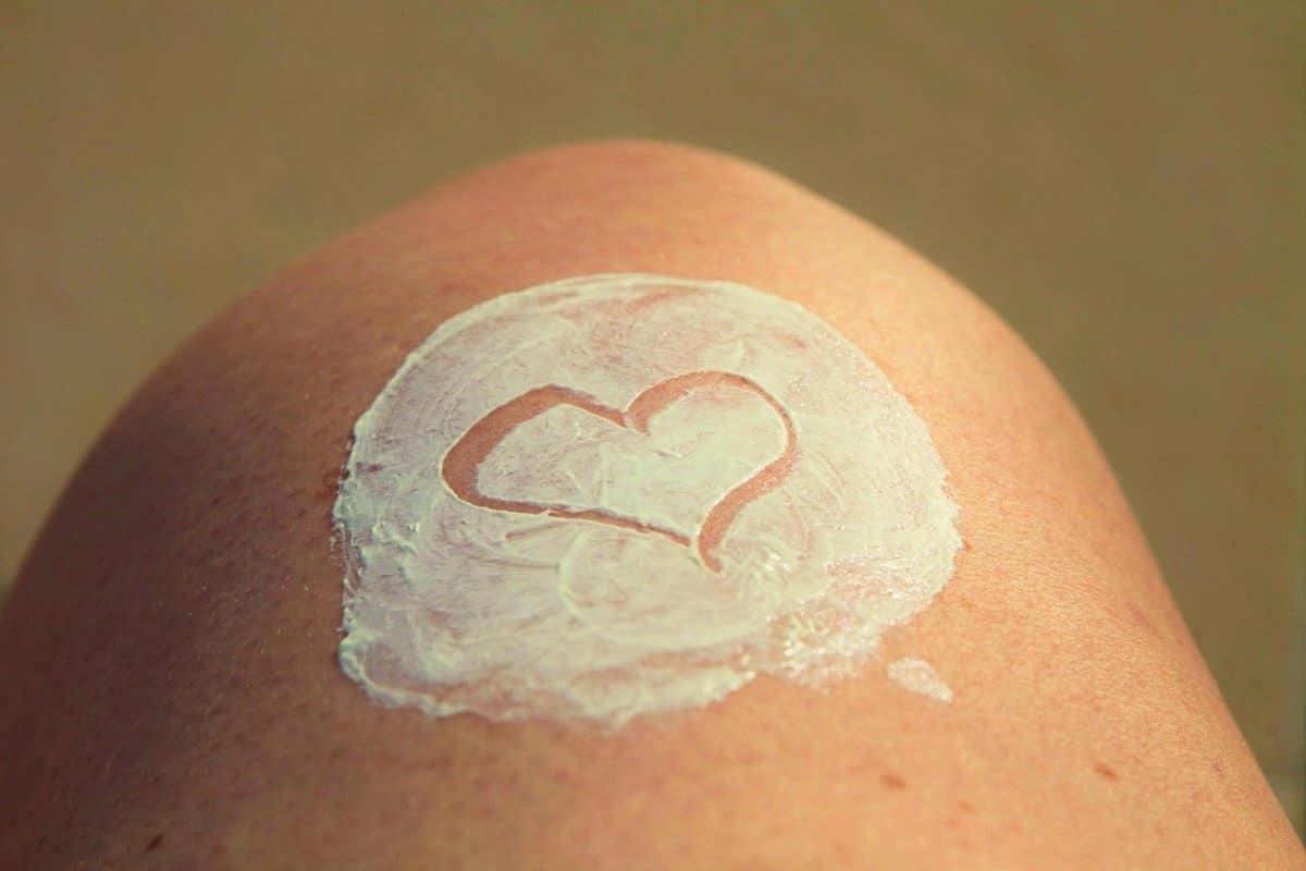 A heart drawn in a patch of sunscreen on a knee