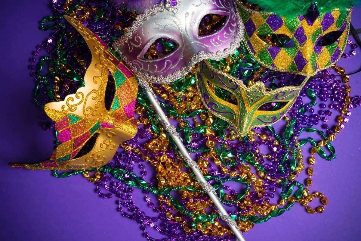 A collection of Mardi Gras masks on a purple background.