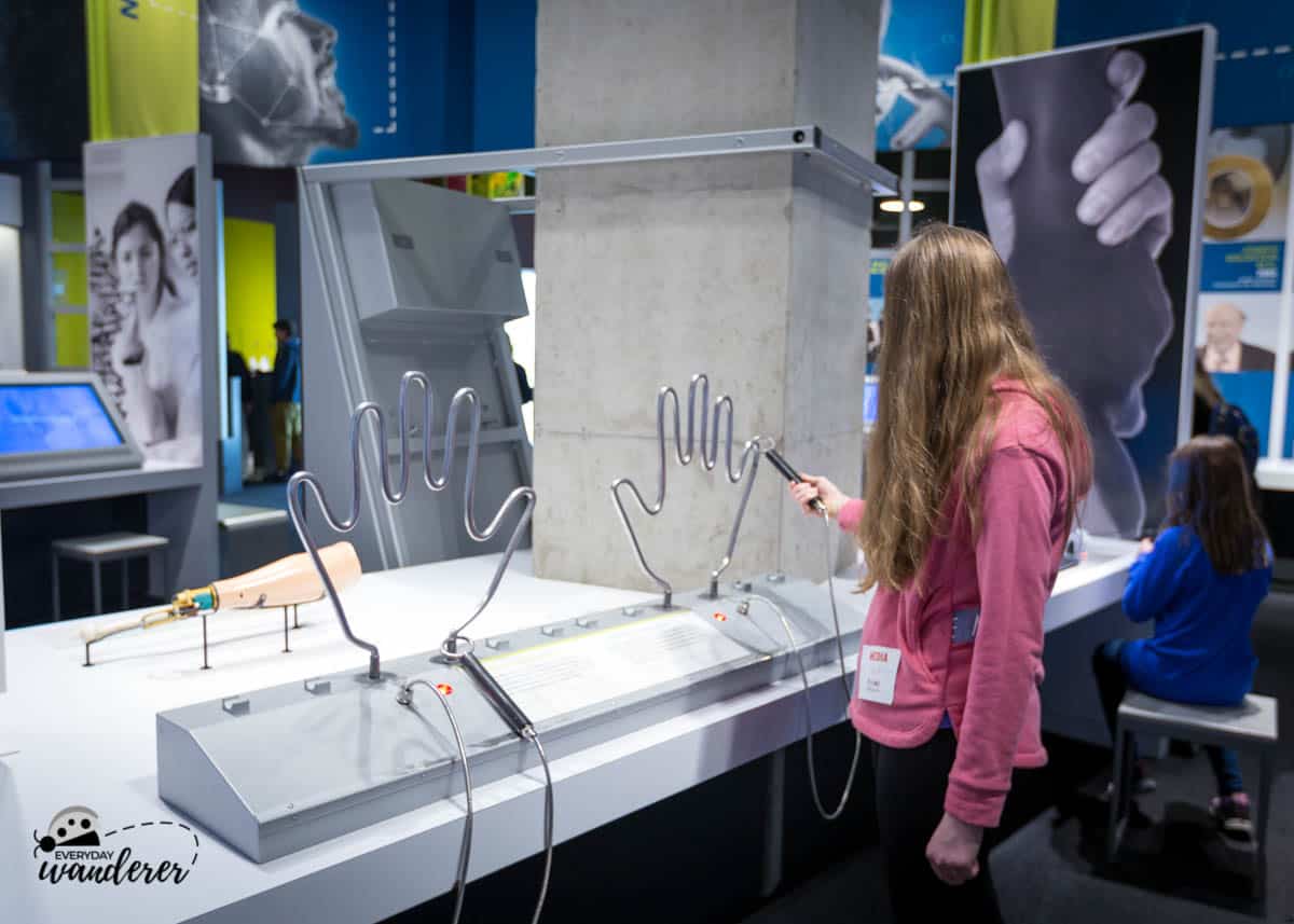 Louise tests her eye-hand coordination at the Perot Museum.