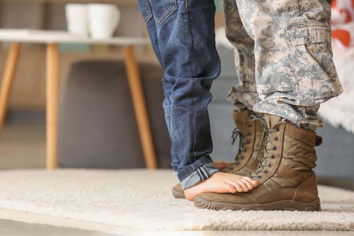 A child stands on his Dad's Army boots