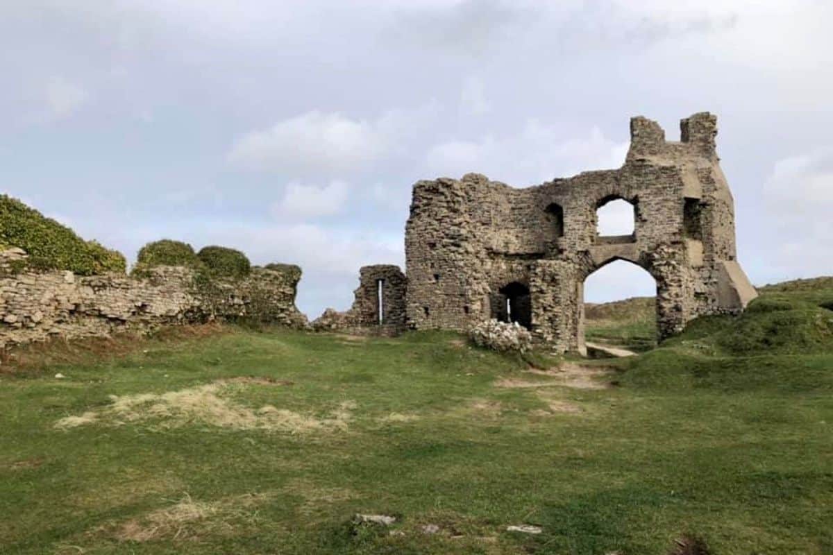 The remains of Pennard Castle sit high on a hill overlooking the beach.