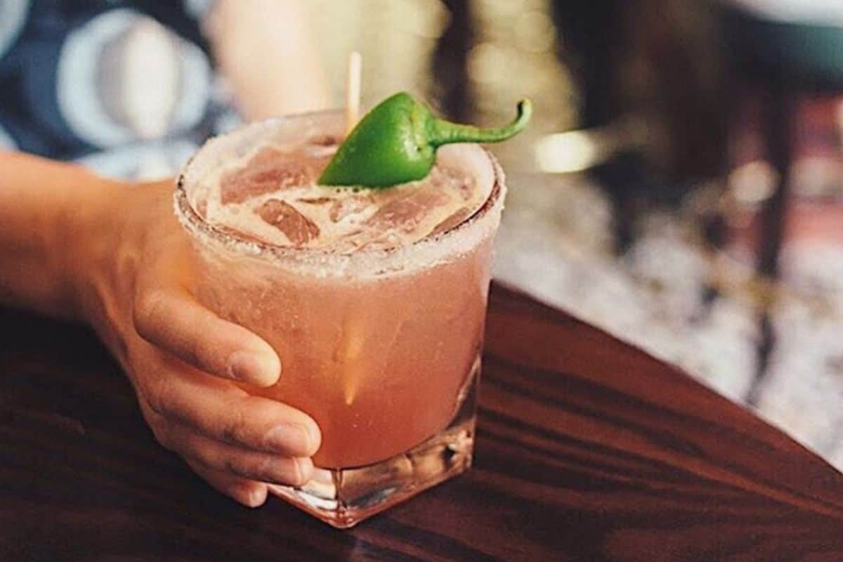 Woman holding huckleberry margarita