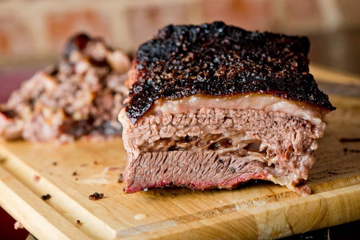 A chunk of barbequed brisket on a wooden cutting board