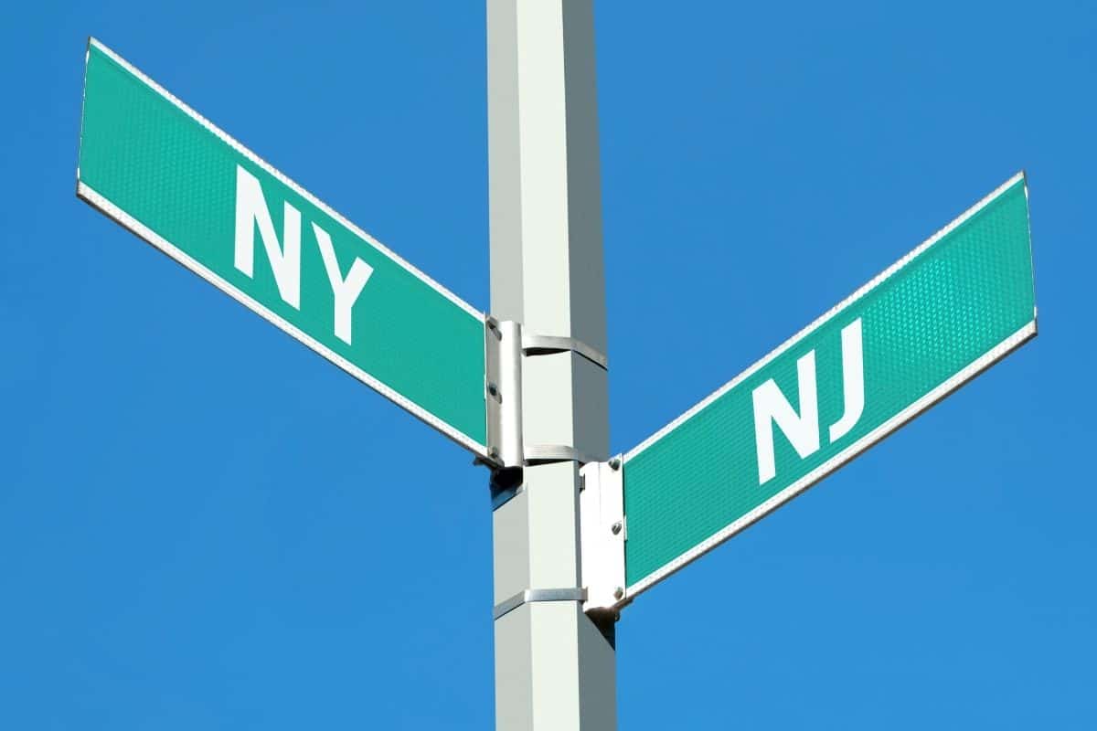 Green street signs showing the intersection of New York and New Jersey