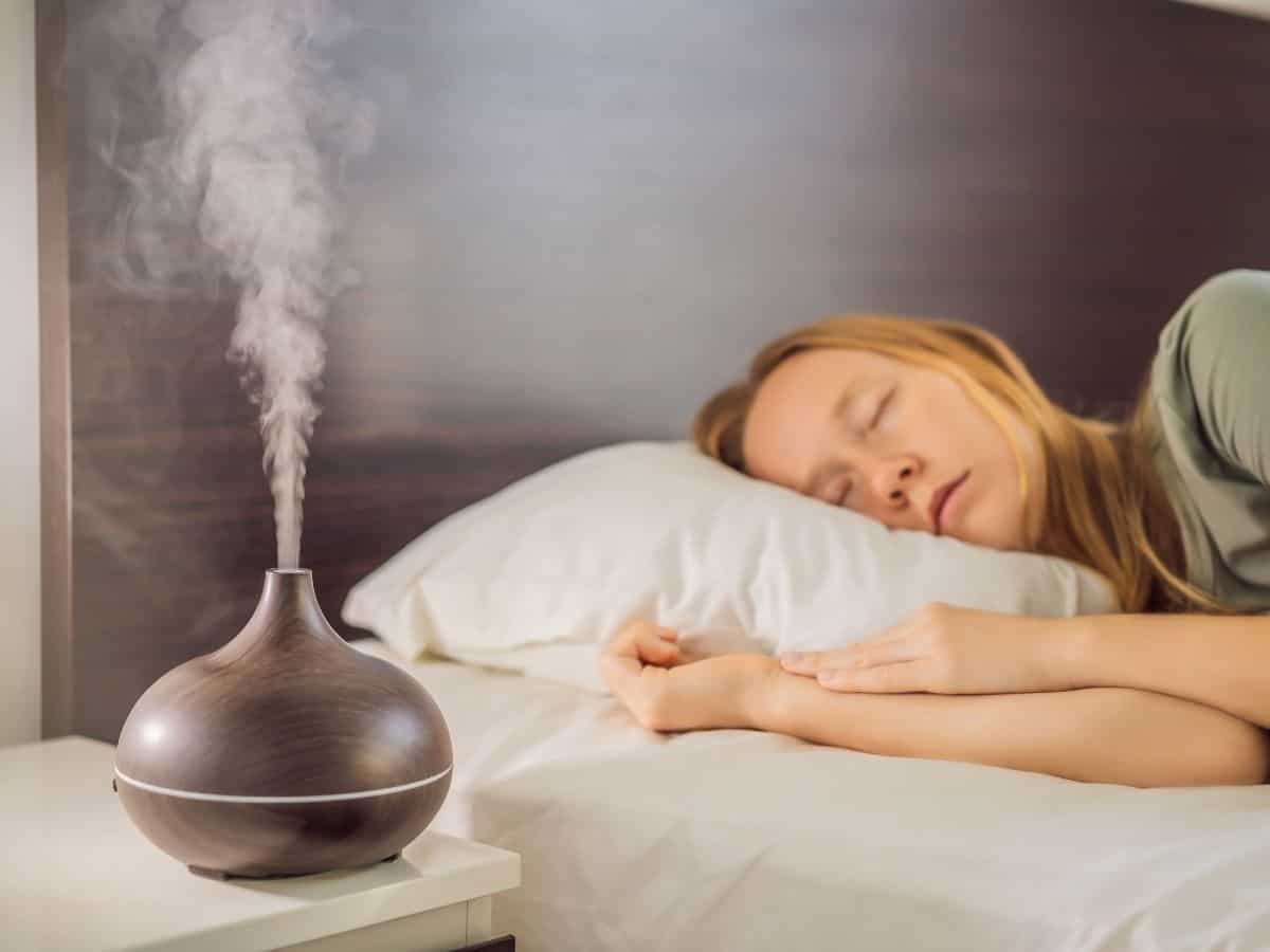 Woman sleeping with diffuser in foreground