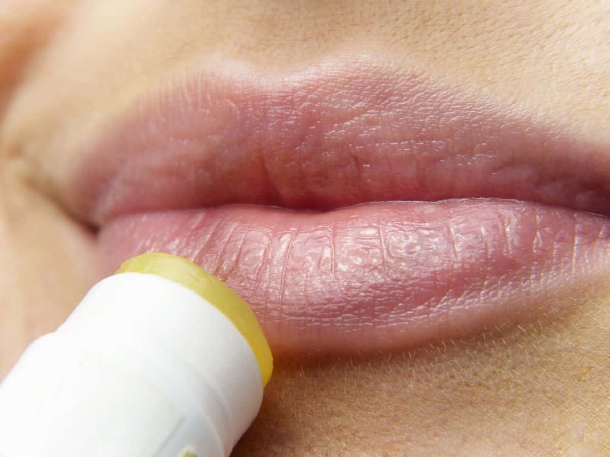 Woman applying lip balm to her lips