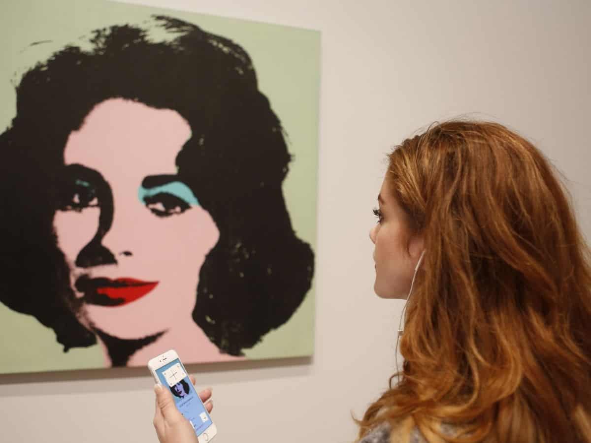A woman admiring a painting of Liz Taylor by Andy Warhol at the Chicago Art Institute