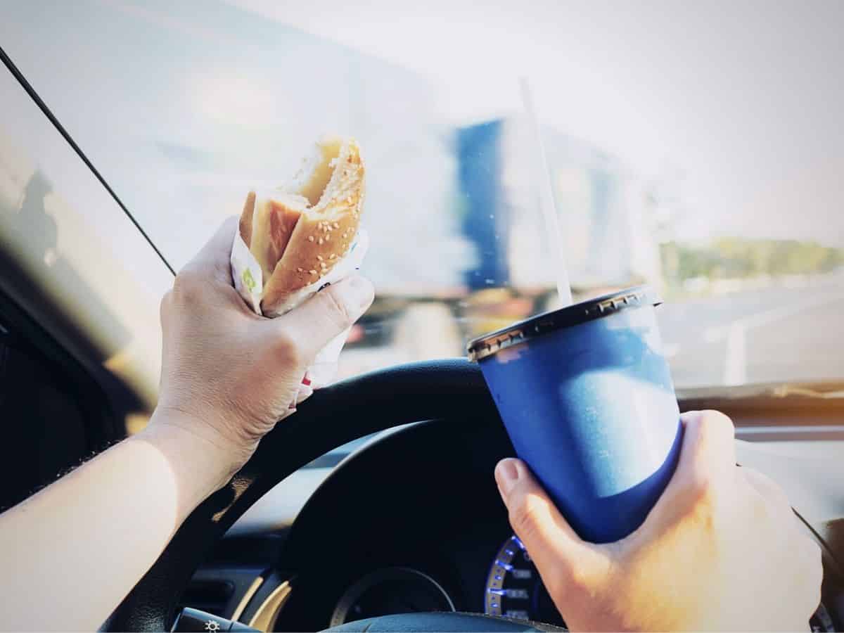 Person Eating and Drinking While Driving a Car