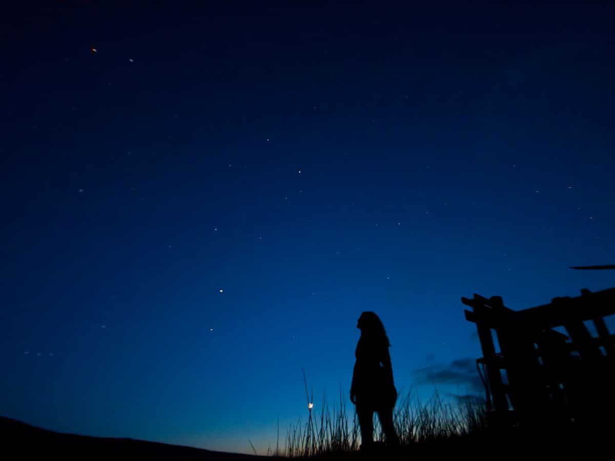 Woman Looking Up at Stars in Sky