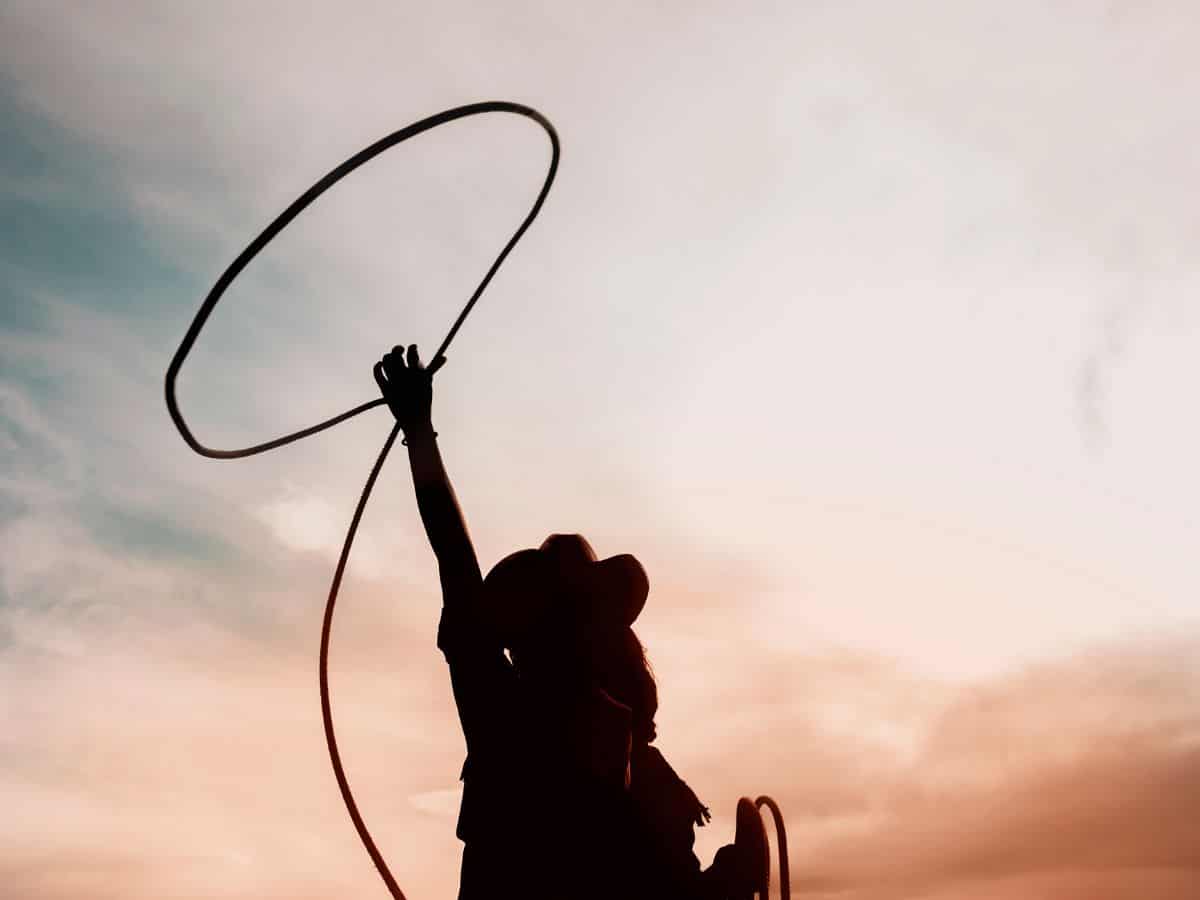 Cowgirl Throwing Lasso at Sunrise