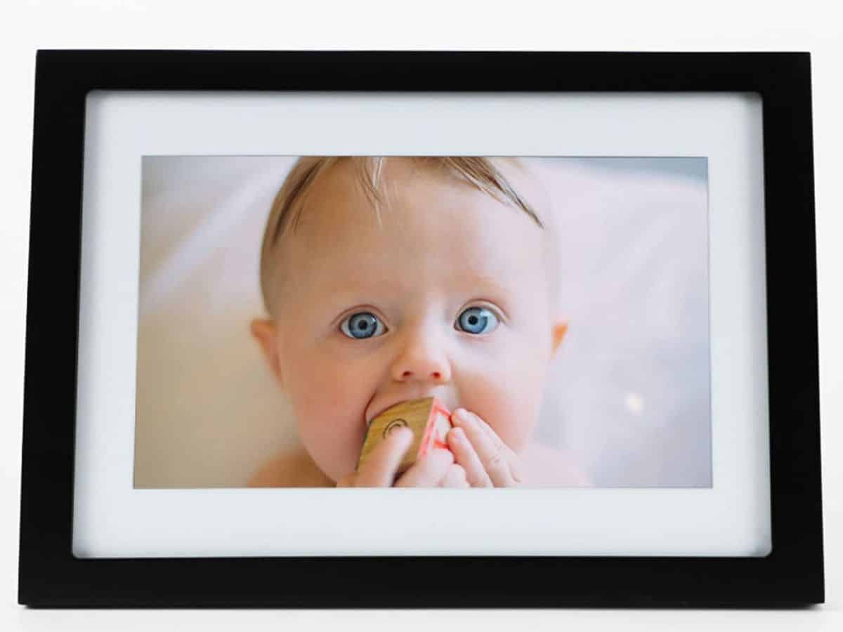 A digital photo frame displaying a photo of a baby