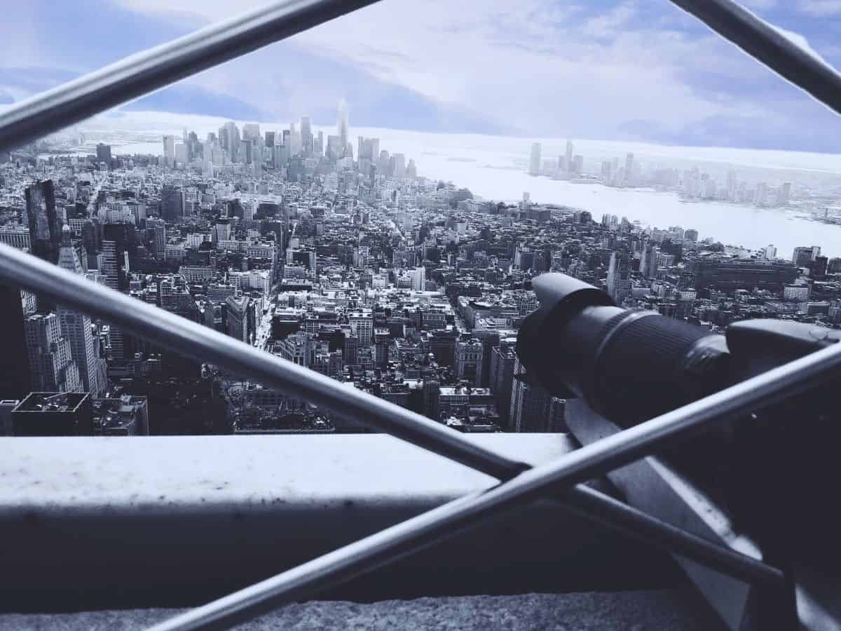 A person taking photos of New York with a long lens from the Empire State Building