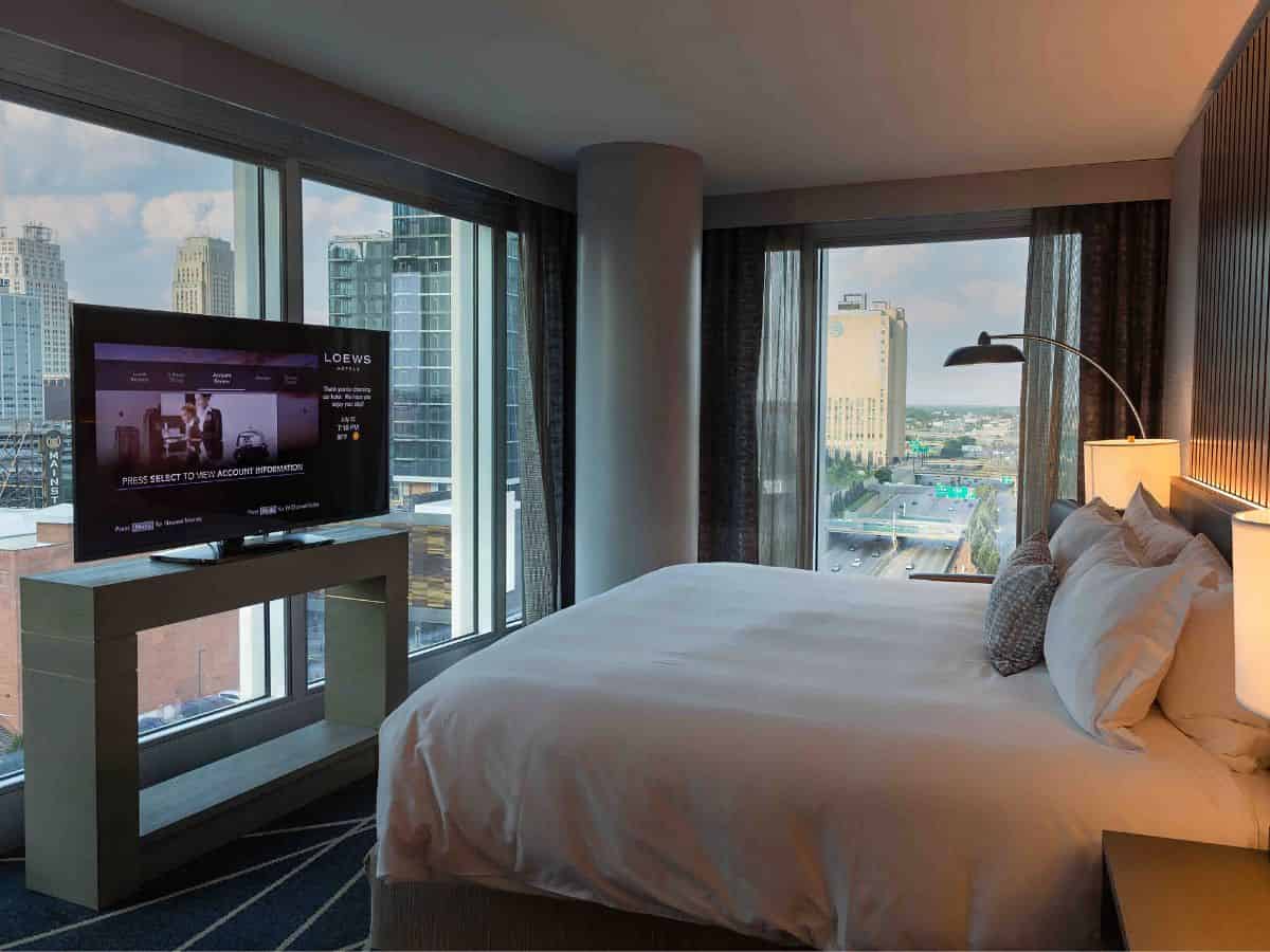 A corner suite at Loews Kansas City Hotel with a city view and a TV.