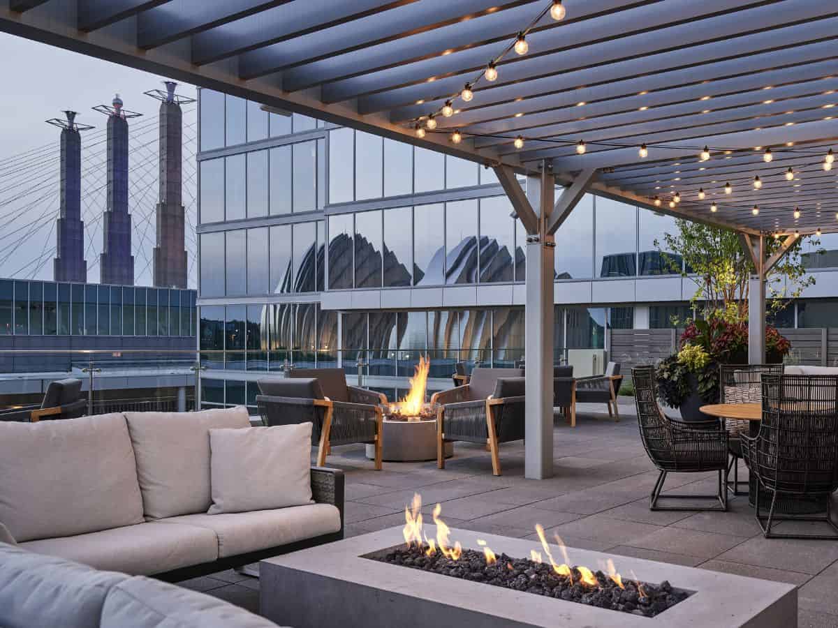Outdoor patio with a fire pit and cozy couches at Loews Kansas City Hotel.