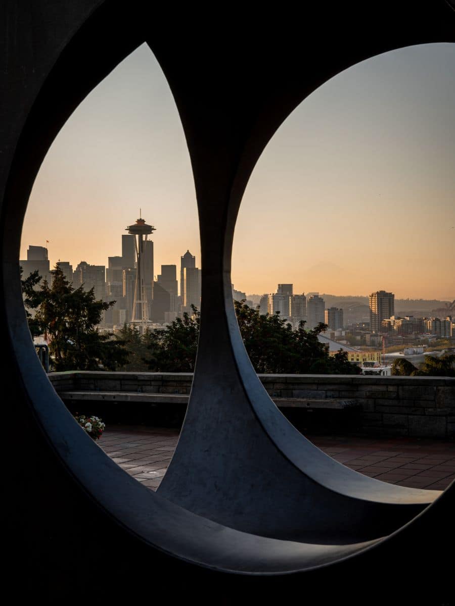 A mesmerizing view of the Seattle skyline seen through a circular frame in Kerry Park as night falls.
