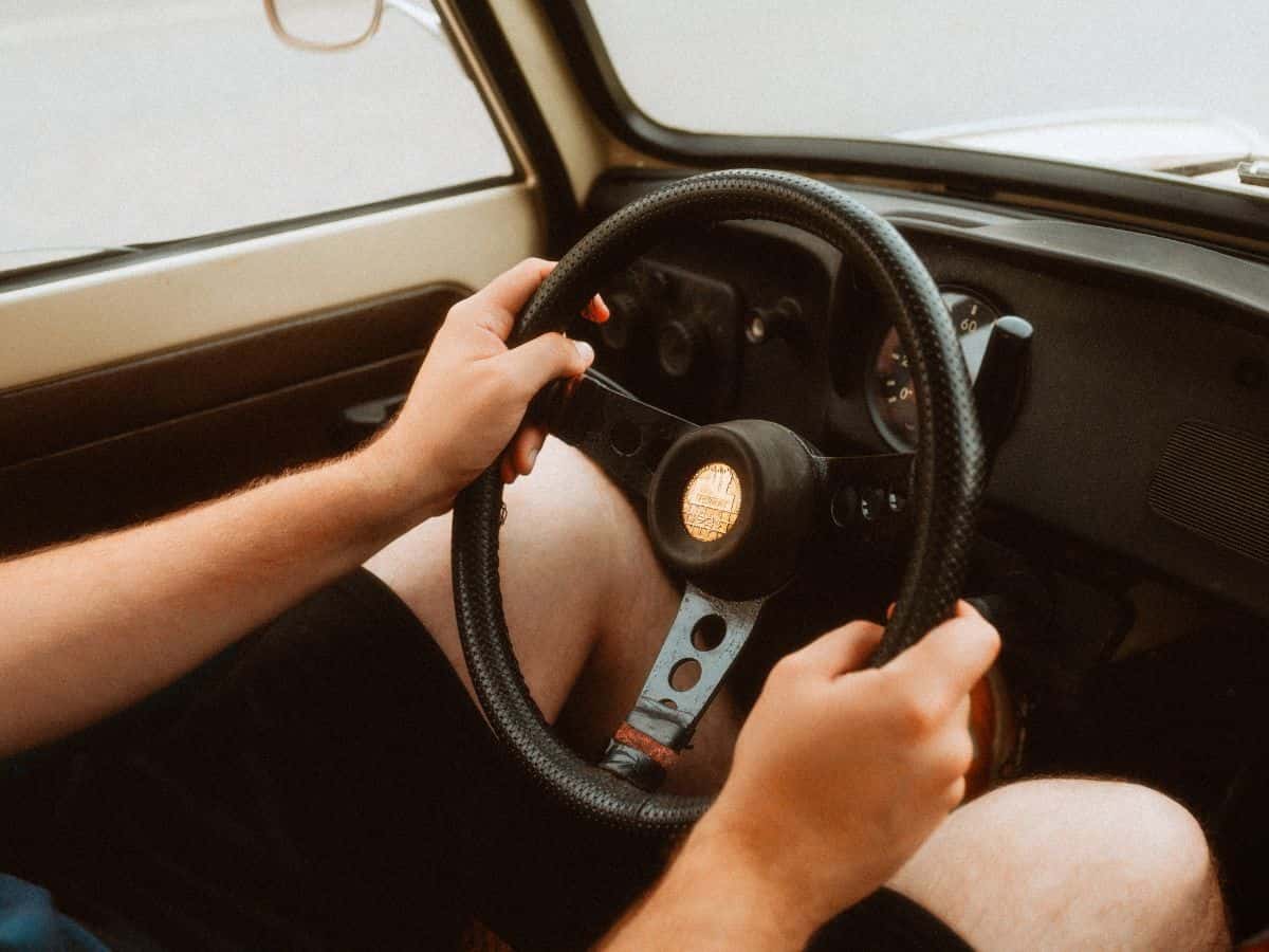 A man sitting at the steering wheel of a classic Trabant car.