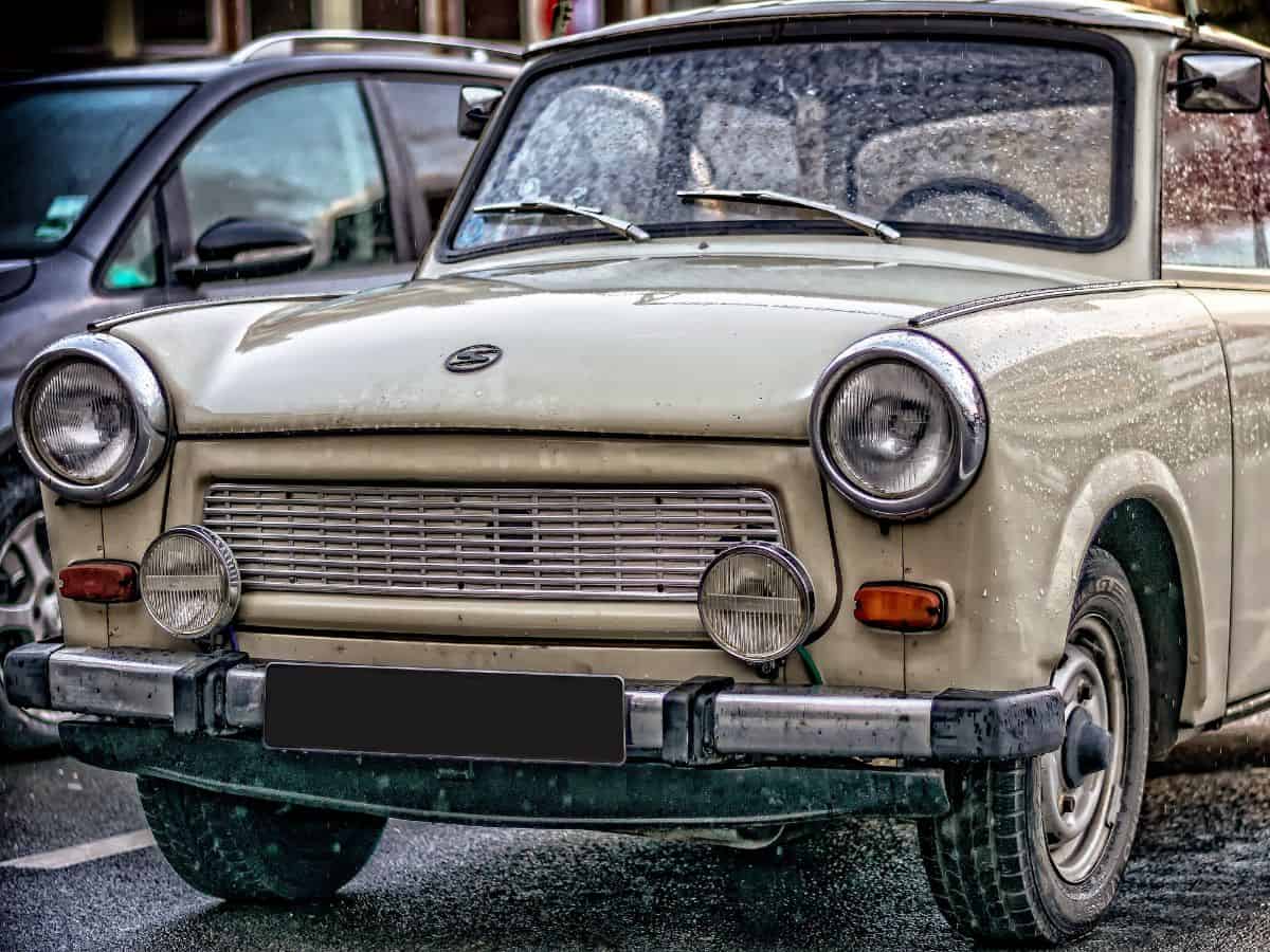An old Trabant car is parked on the street.