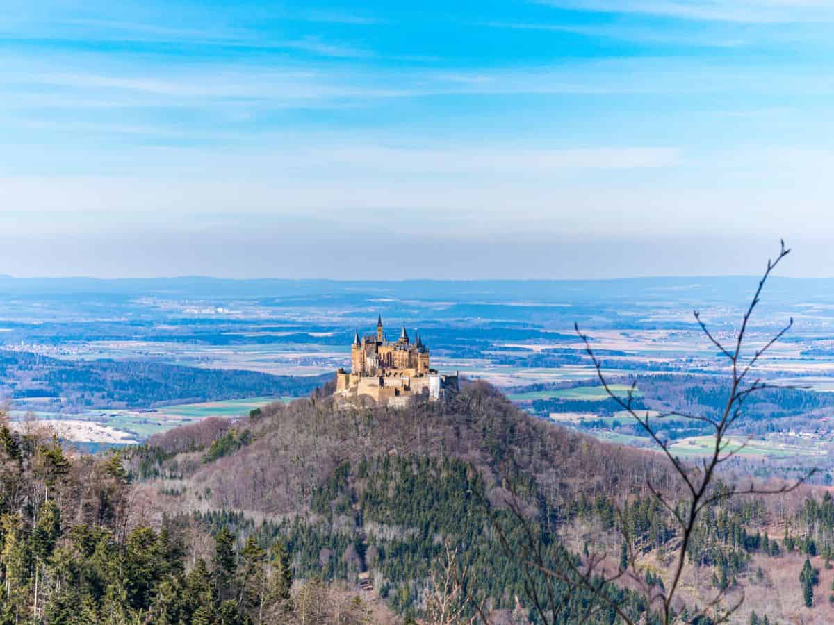 A majestic German castle sits on top of a hill, offering breathtaking views of the surrounding valley.