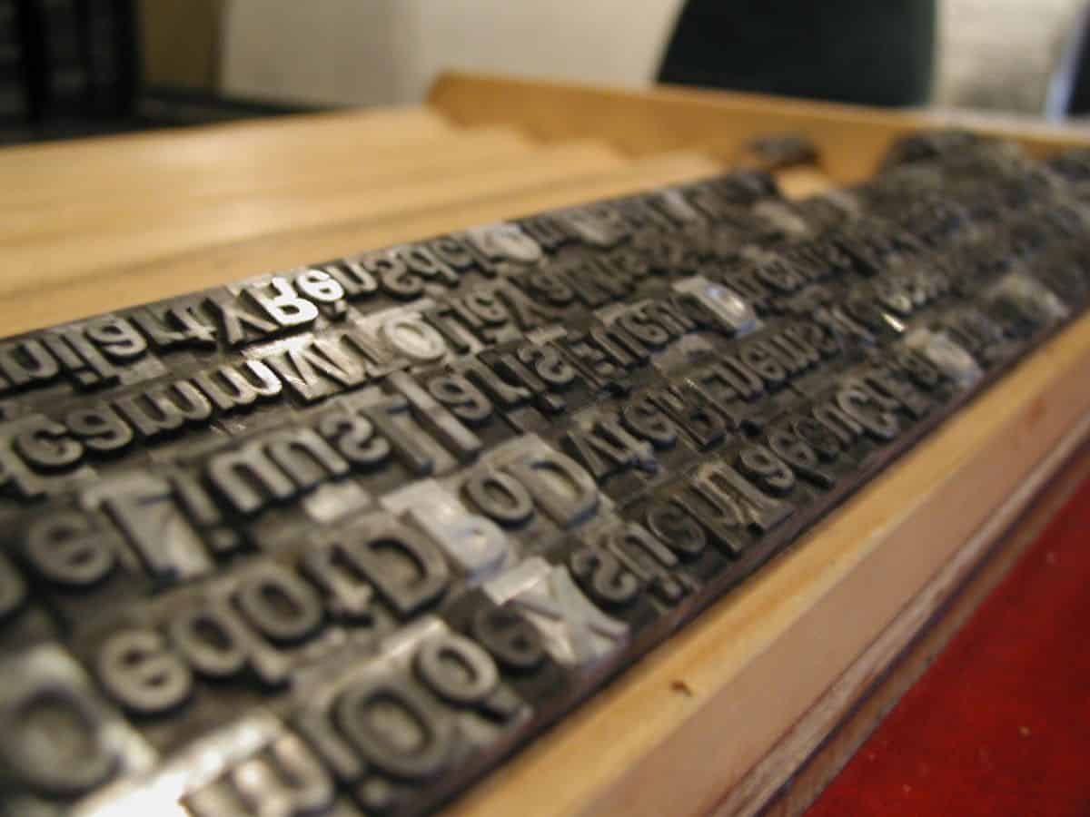 A metal type set on top of a wooden table.
