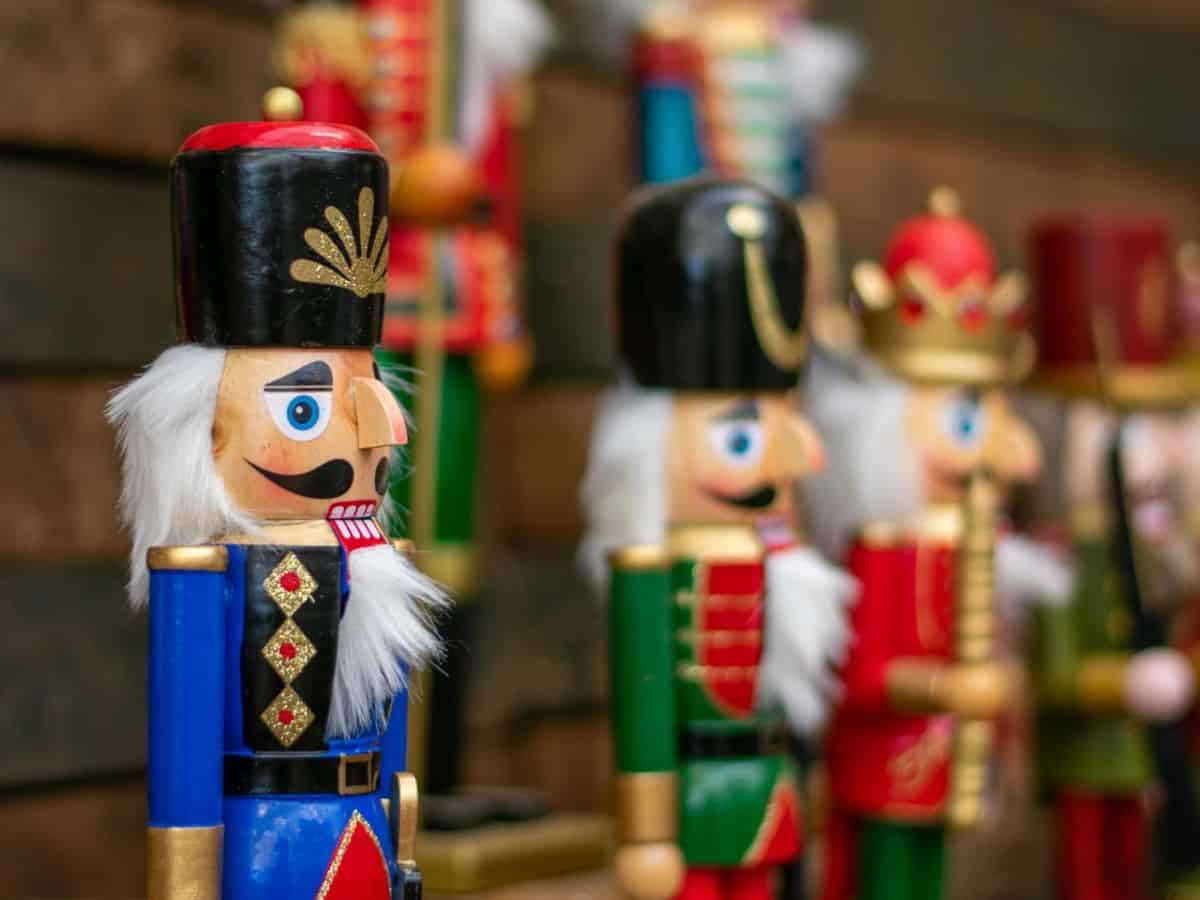 A row of traditional German nutcrackers on a wooden shelf at a German Christmas market.