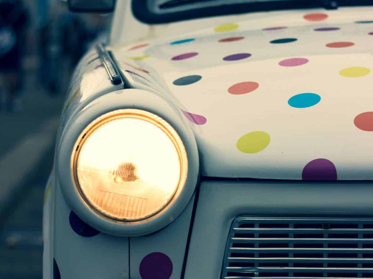 A trabant car with polka dot paint on the front.