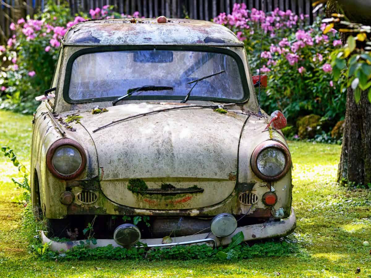 An old Trabant car sits in the grass.