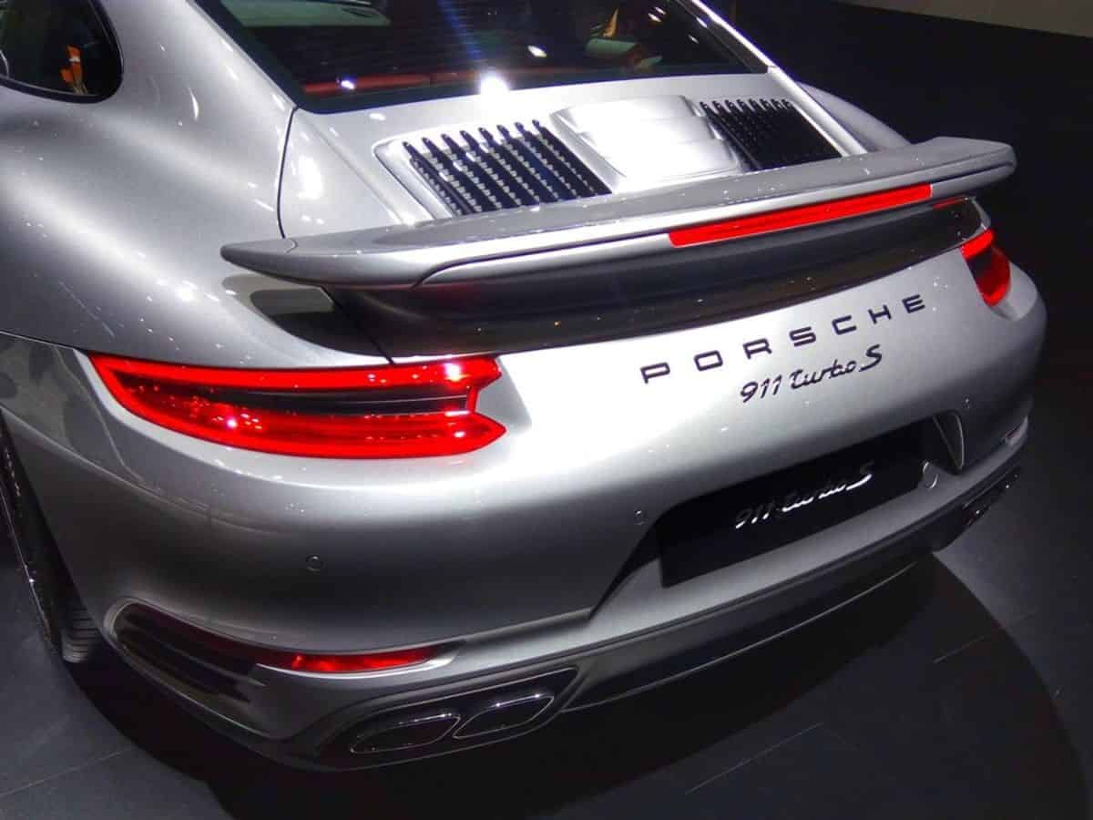 The rear end of a silver Porsche 911, a famous luxury car made in Germany.