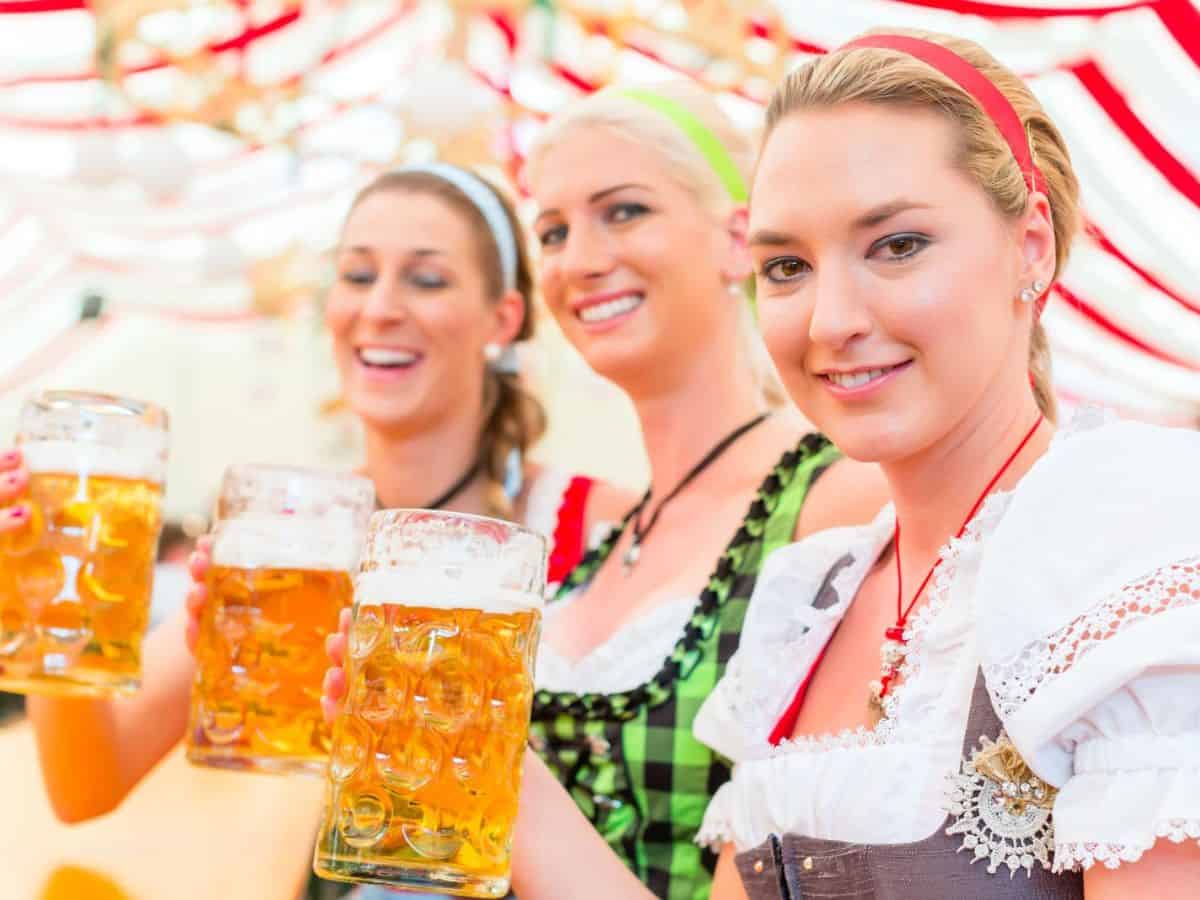 Women in traditional oktoberfest outfits holding beer mugs, showcasing what Germany is famous for - Oktoberfest and beer.