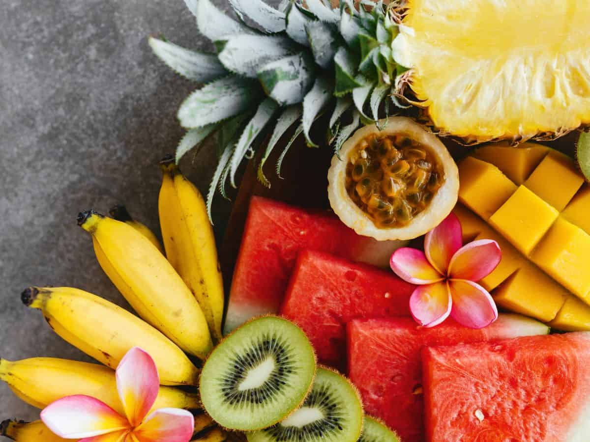 A plate of tropical fruits on a gray background, perfect for a Hawaiian luau feast.