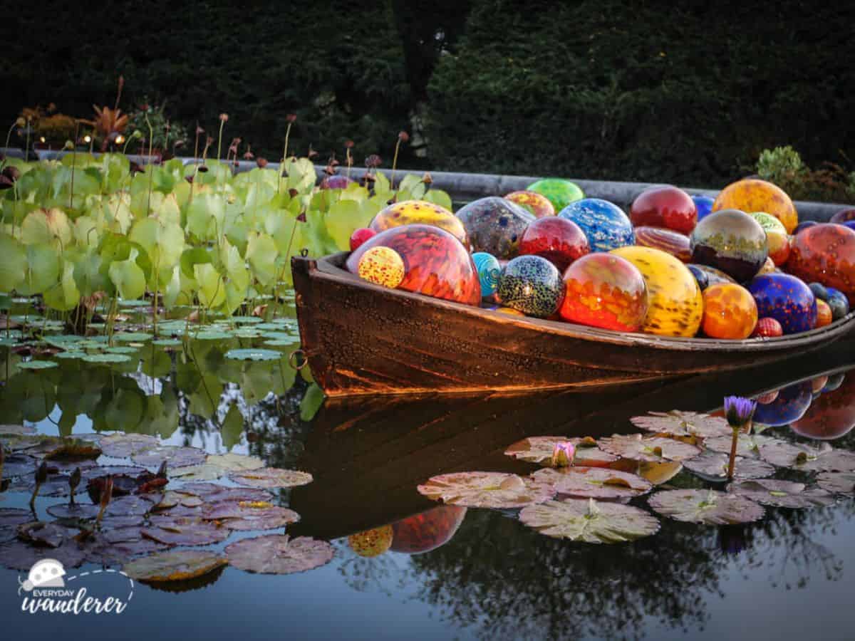 A boat filled with colorful glass balls and surrounded by water lilies at the Biltmore.