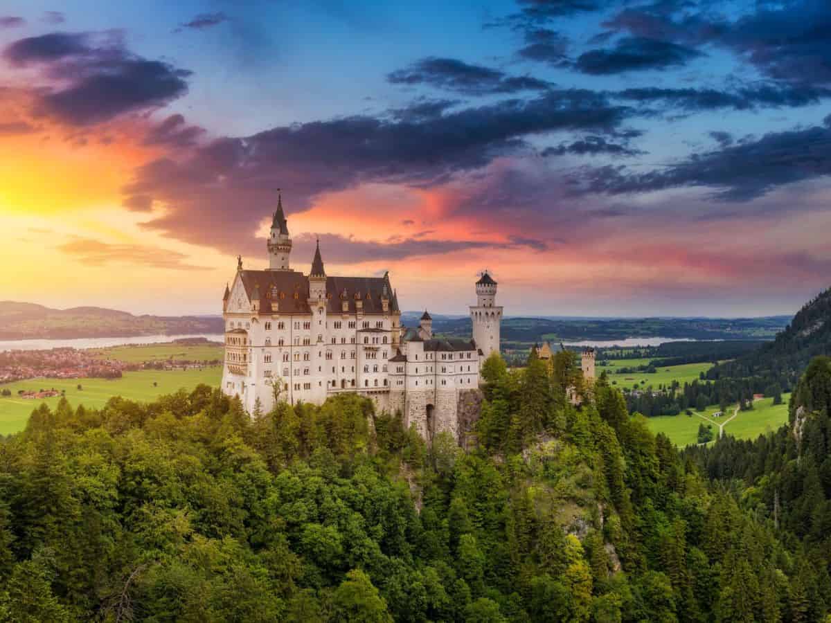 Neuschwanstein castle, one of the iconic German castles, bathed in the warm glow of a Bavarian sunset.