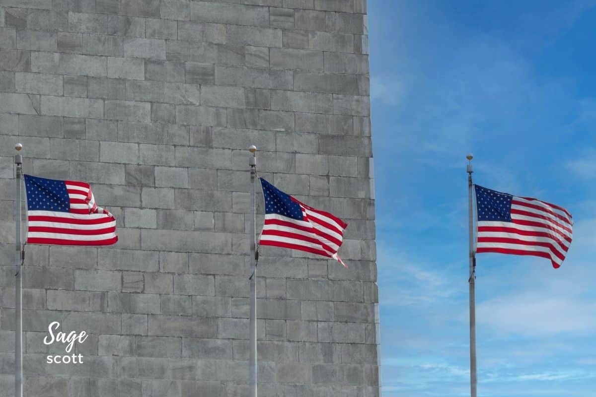 Three American flags flying in front of the Lincoln Memorial, showcasing the patriotic spirit of the United States.