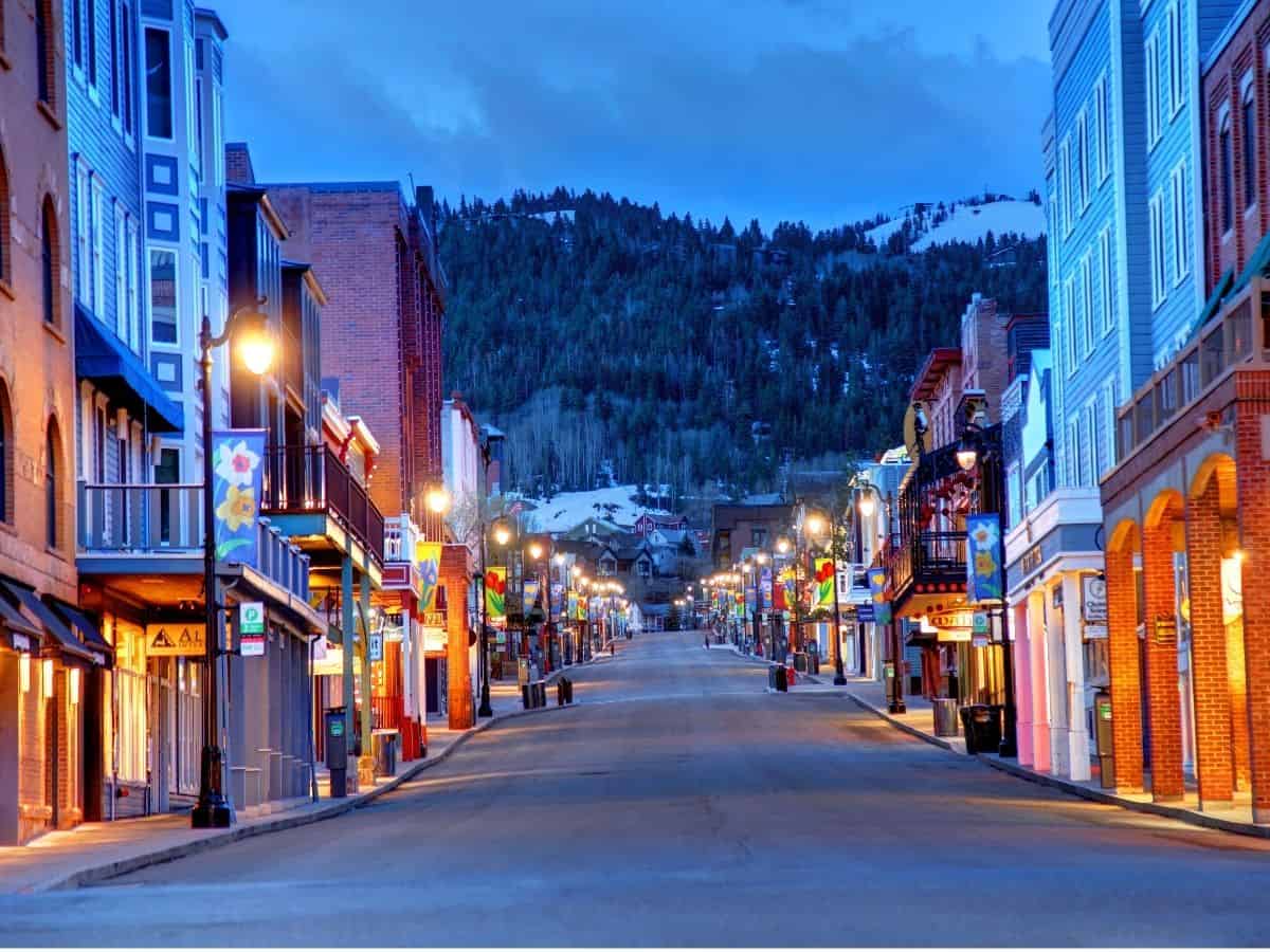 A street in downtown Park City with a view of a snow-capped mountain.