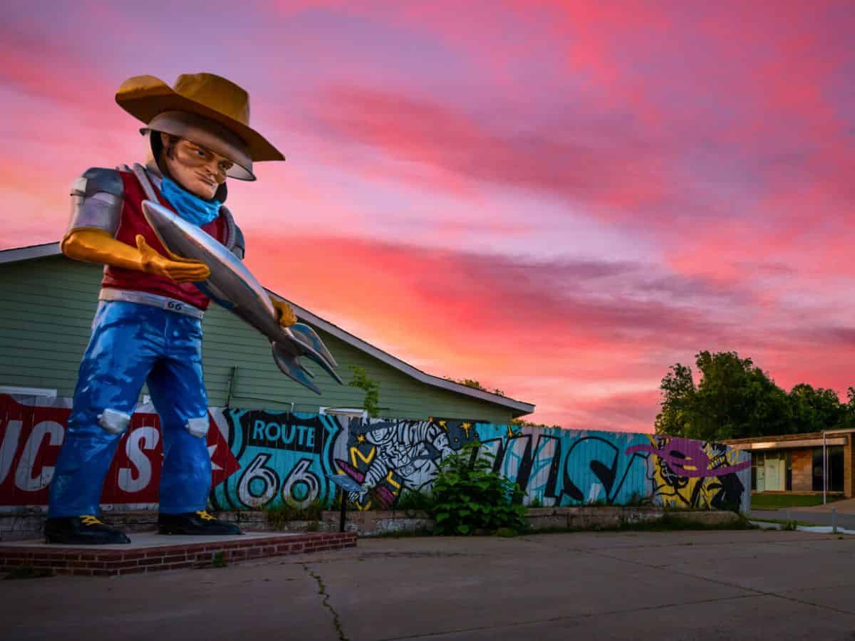 Buck Atom statue on Route 66 in Tulsa, Oklahoma, at sunset.