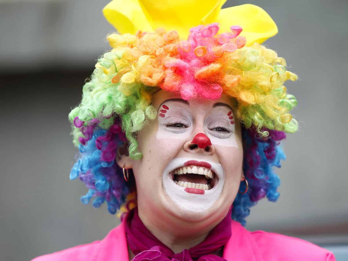 A woman dressed as a clown with colorful wig.