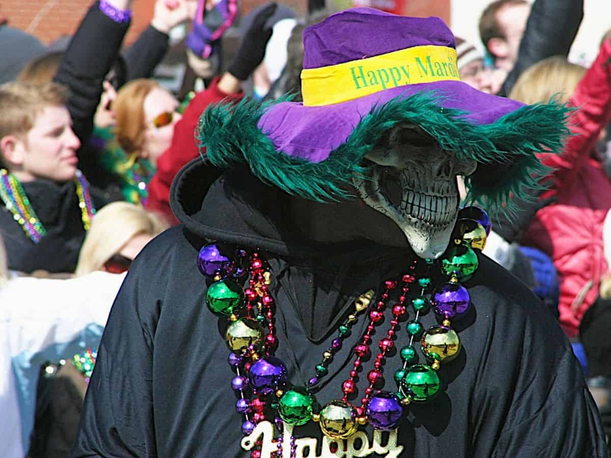 A man wearing a highly accessorized Mardi Gras costume.