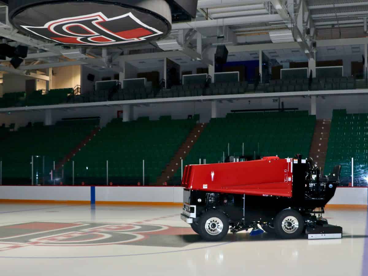 An ice rink with a red and black Zamboni.