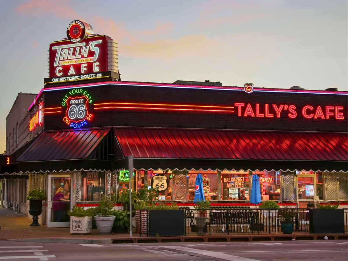 Neon lit exterior of Tally's Cafe along Route 66 in Tulsa at dusk.