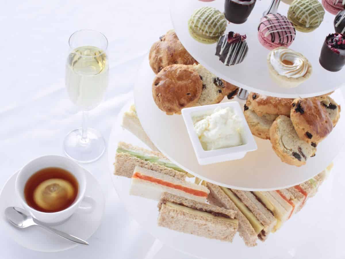 A tray of sandwiches, scones, and pastries at afternoon tea.