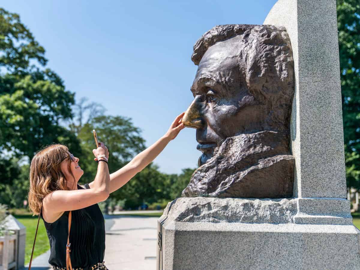 A woman taking a picture of a bust of Abraham Lincoln in Springfield, Illinois.