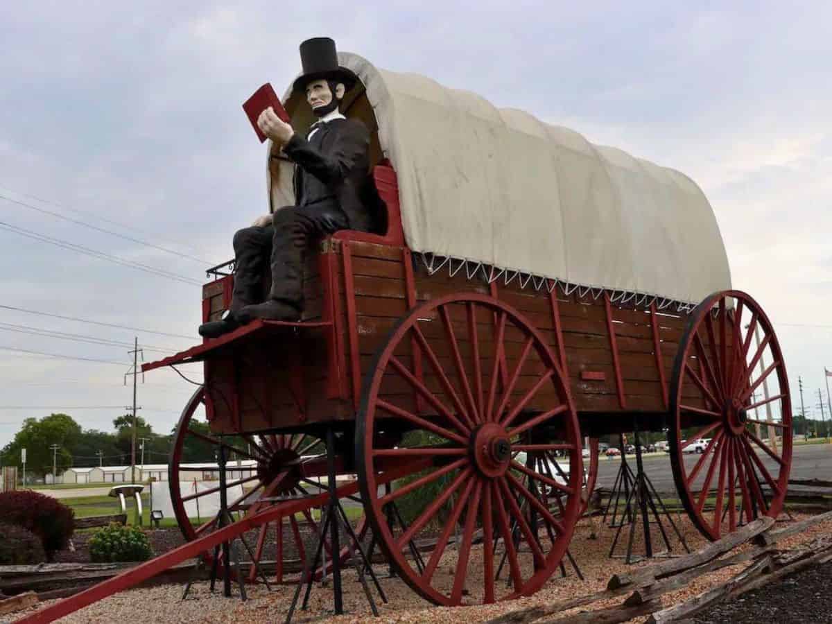 Abe Lincoln sitting on the world's largest railsplitter covered wagon along Route 66 in Illinois.